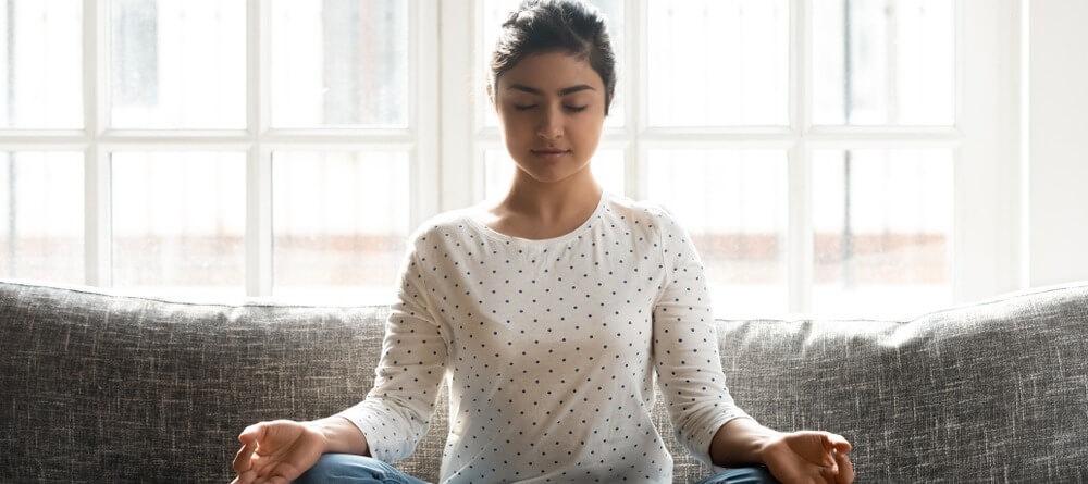 A women peacefully meditating. 