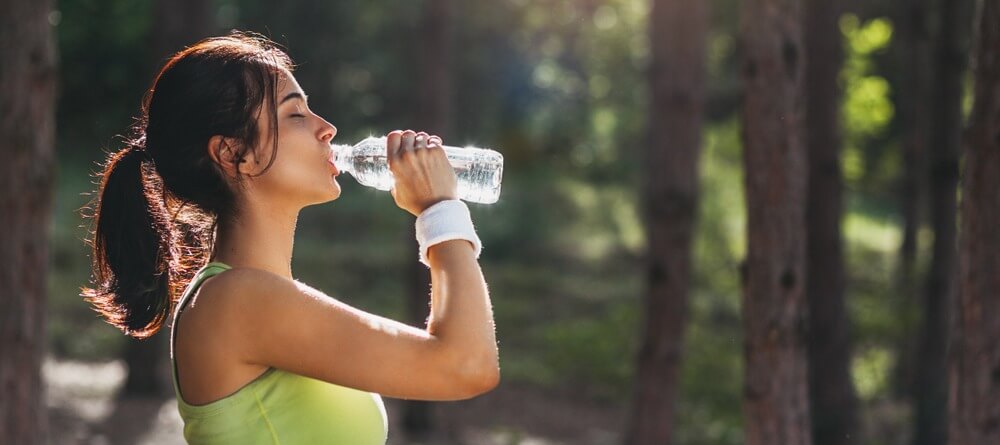 Women drinking water after outdoor exercise. 