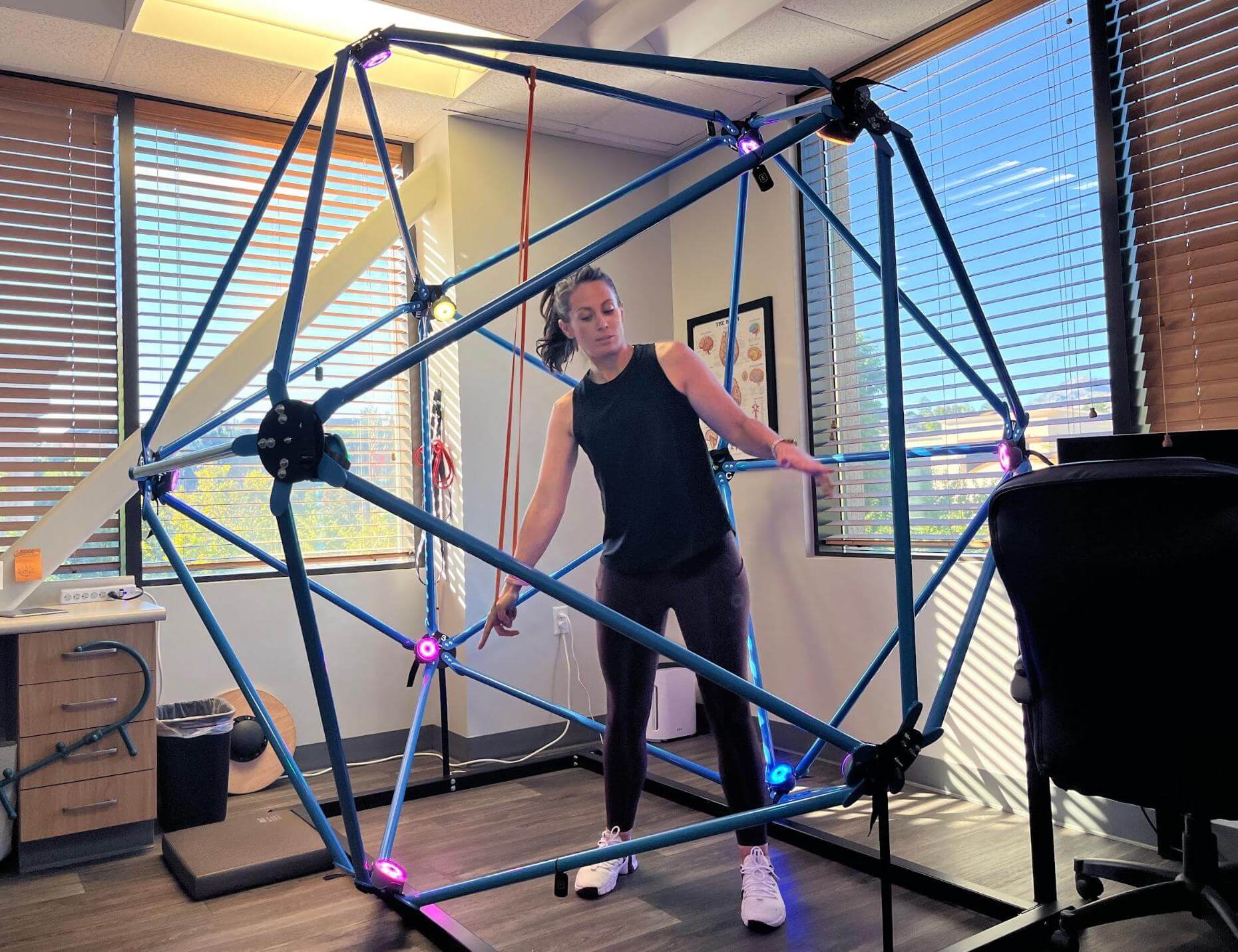 A patient in neurointegration therapy inside a lighted training frame