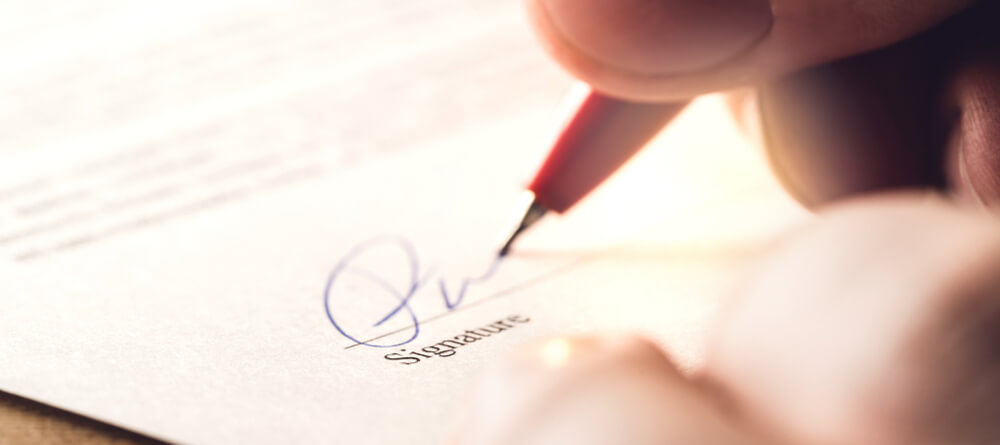 Close up of someone signing a document
