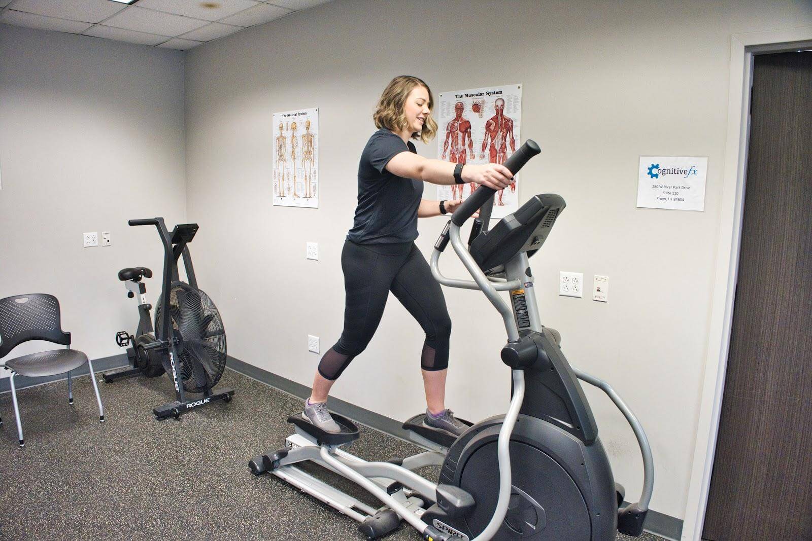 Women warms up on an elliptical. 