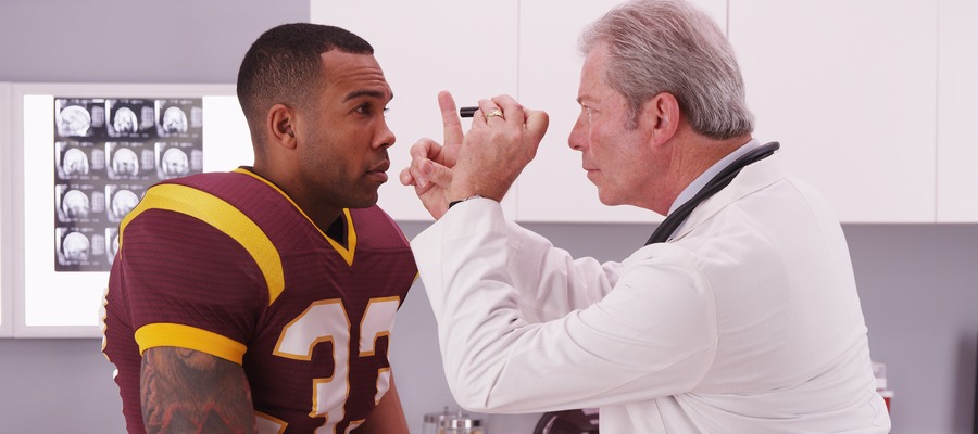 A doctor examines a football player