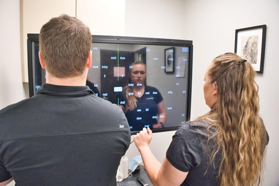 Two therapists demonstrate an exercise using the Dynavision board. 