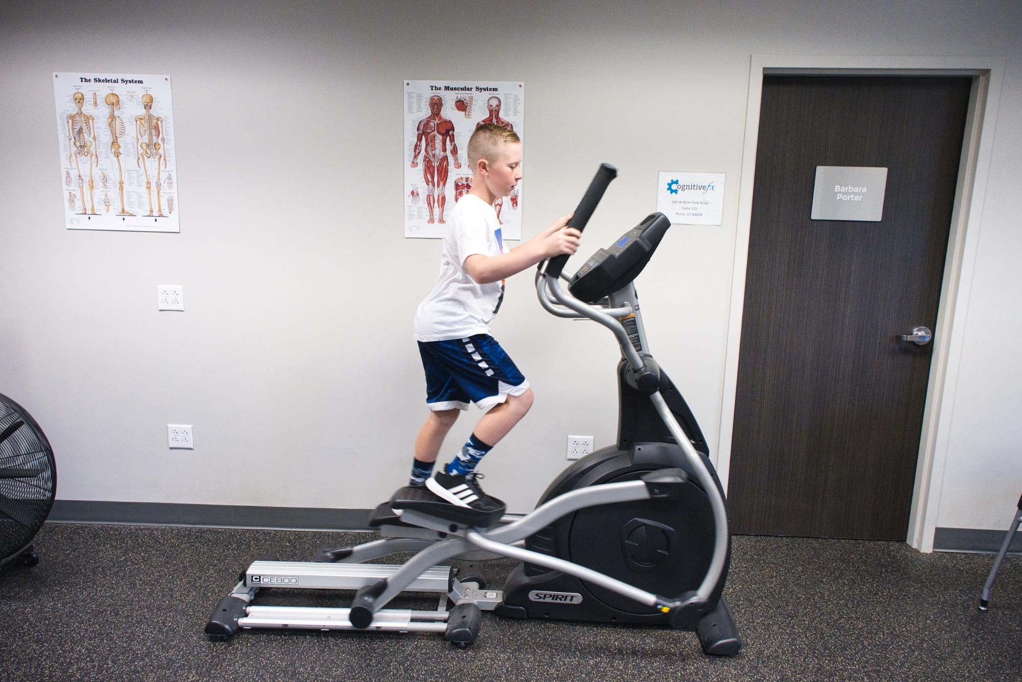 A young man using a cardio machine. 