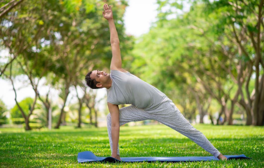 A man doing yoga in the park