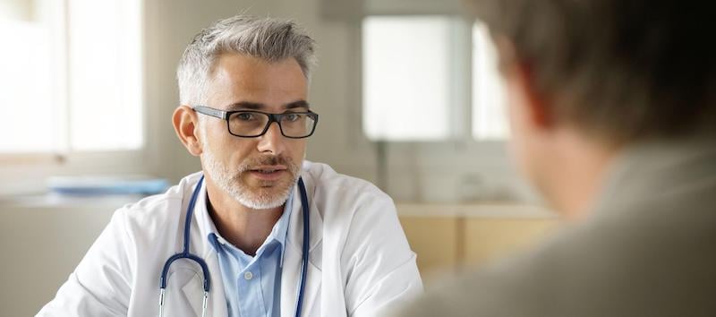 A doctor meets with a client to go over treatment options. 