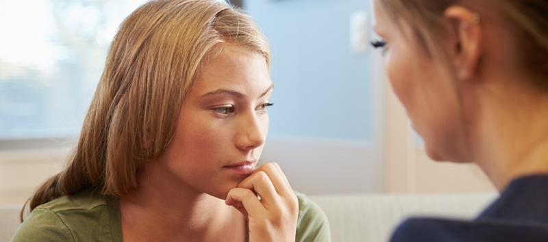 A photo of two women; one of the woman is daydreaming.