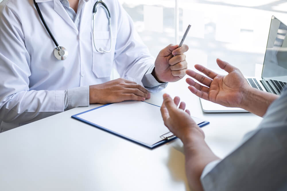 A doctor and patient sitting down talking.