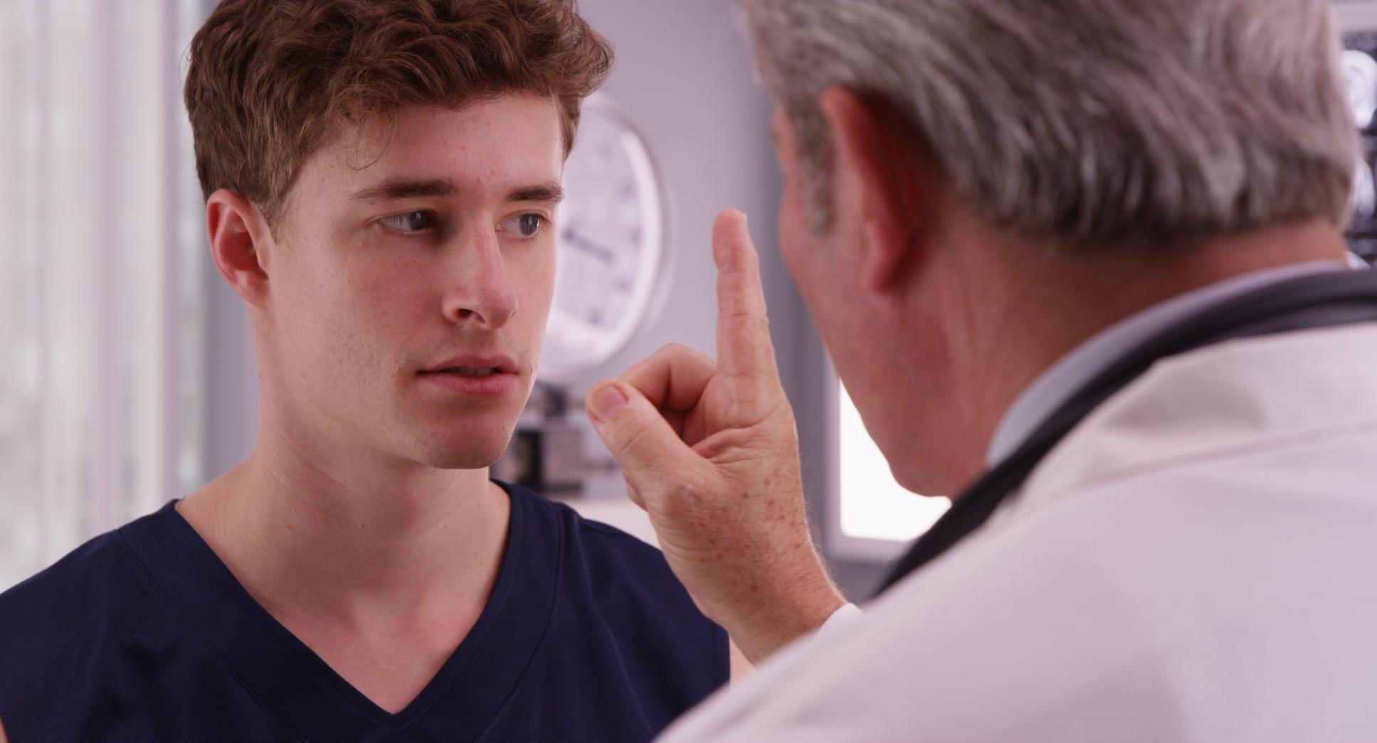 A doctor is performing an eye tracking test with a patient