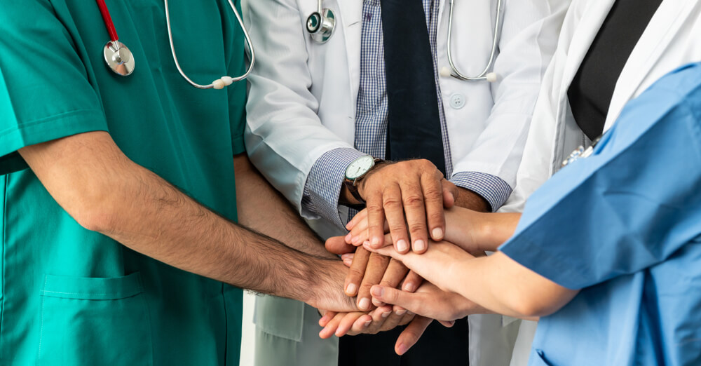 Doctors and nurses doing a team handshake