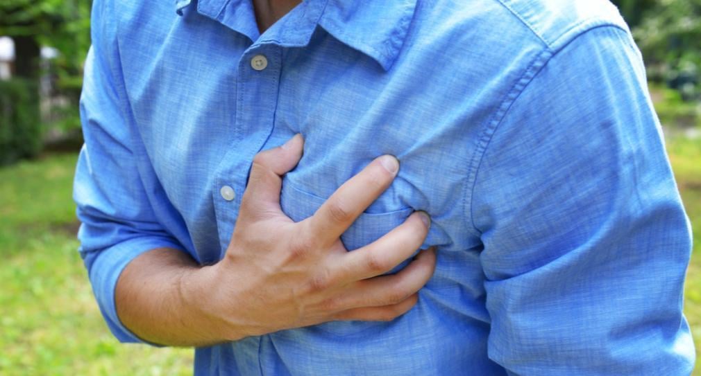 A man is grabbing his chest with his hand.