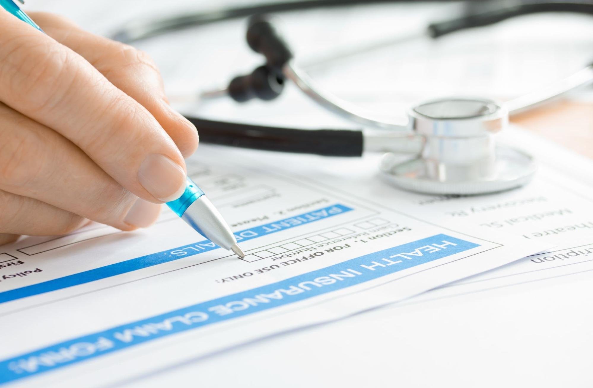 A patient is filling out a health insurance claim form