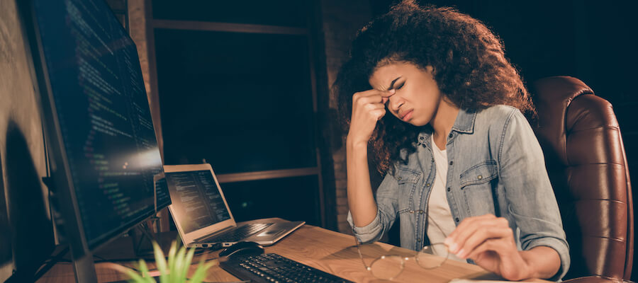 A young woman is overwhelmed sitting at her desk