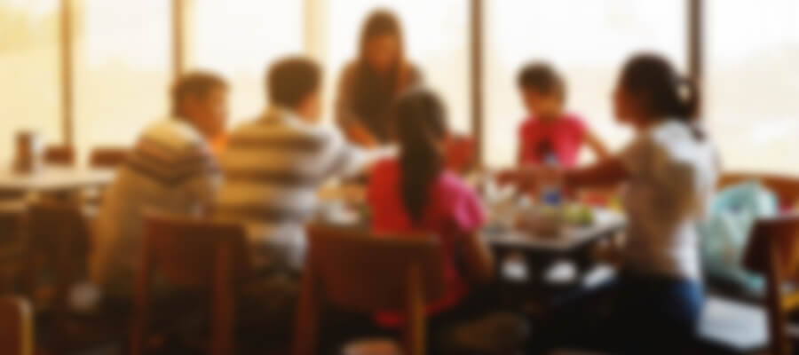 A blurry photo (overstimulated view) of a family sitting down at a table having a dinner