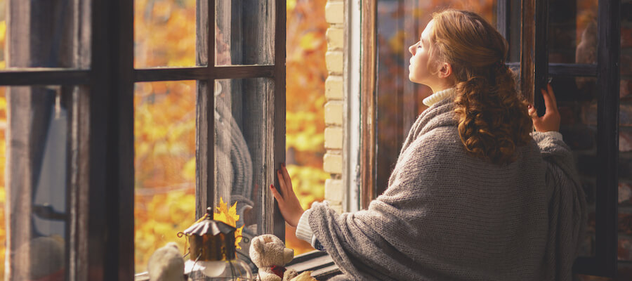 A woman staring out hte window into the sun 