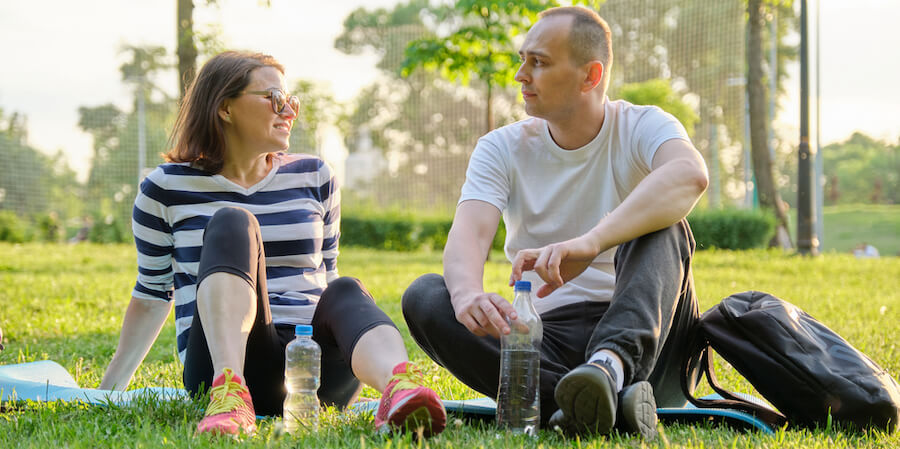 A young couple sitting in the grass after a long walk 