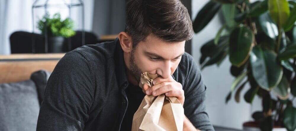 Man breathing into paper bag. 