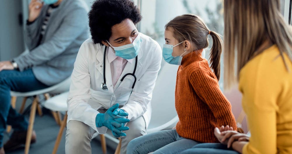 A doctor discussing treatment with her young patient and mother.