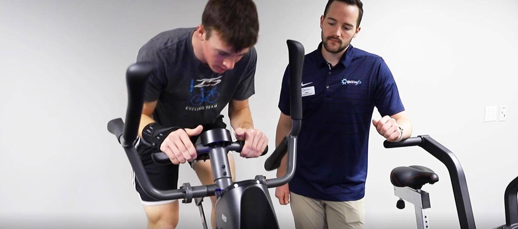 A CFX therapist works with a patient on an elliptical