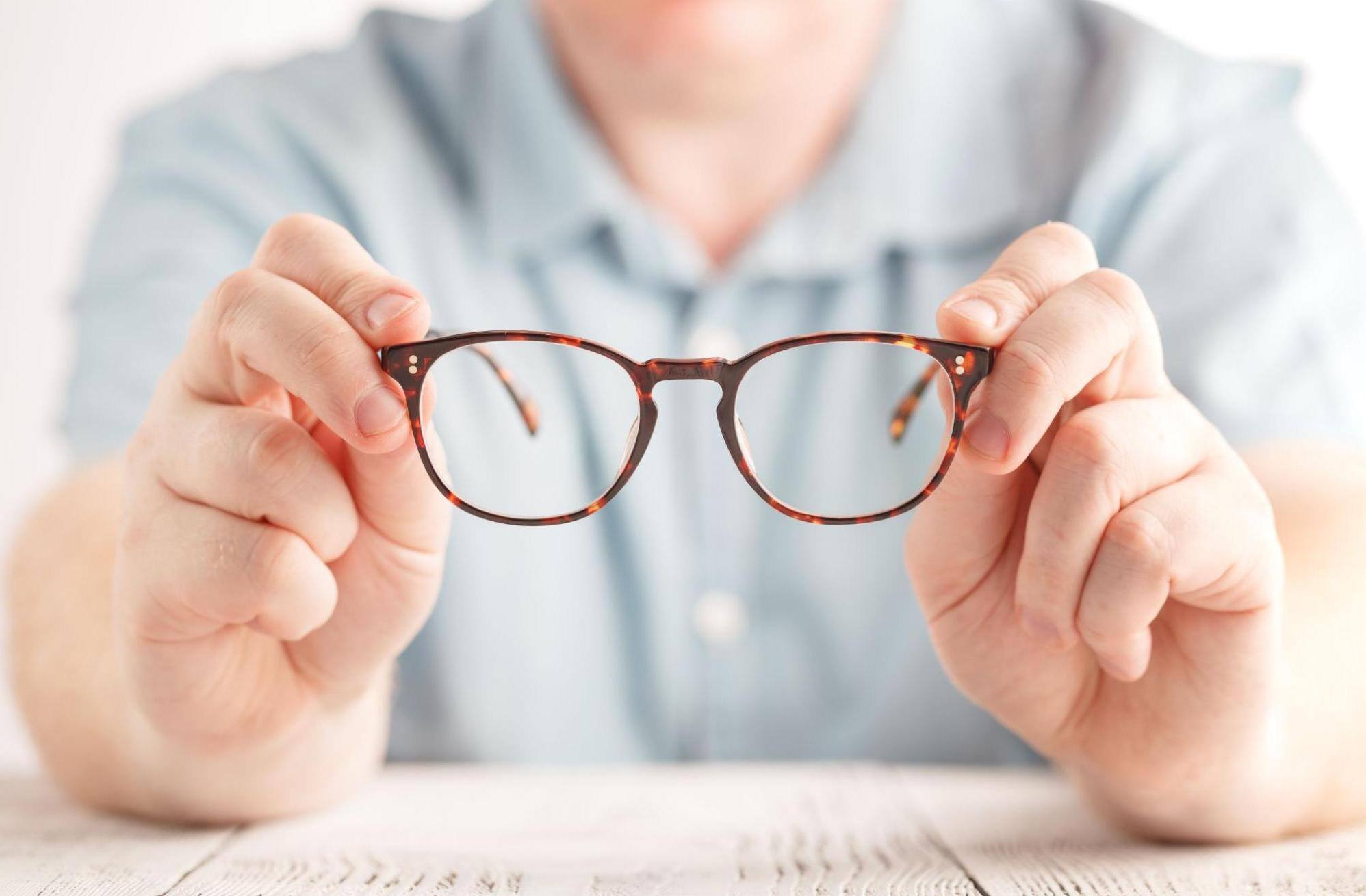 man holding his glasses