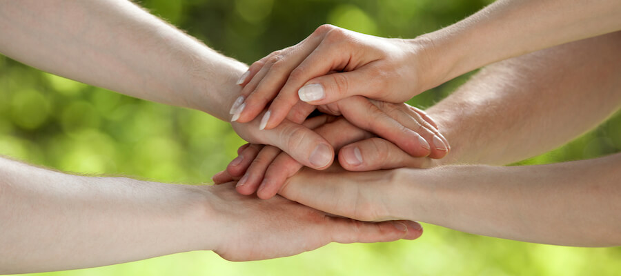 A photo showing a family putting their hands on top of each other.