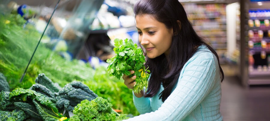 A woman shopping for produce in the grocery store.