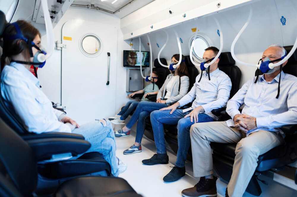 Multiple people receiving oxygen therapy in a hyperbaric chamber