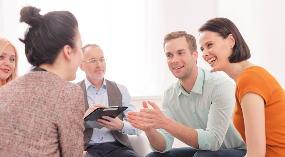 A group of 5 people meeting for a support group.