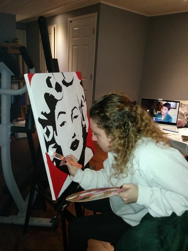 A photo of Sam painting an abstract Marilyn Monroe.