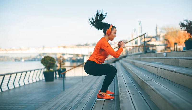 A woman is exercising on stairs.