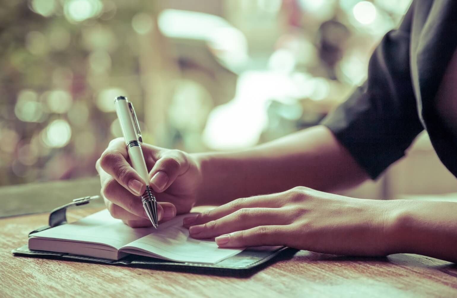 woman writing in her weekly planner