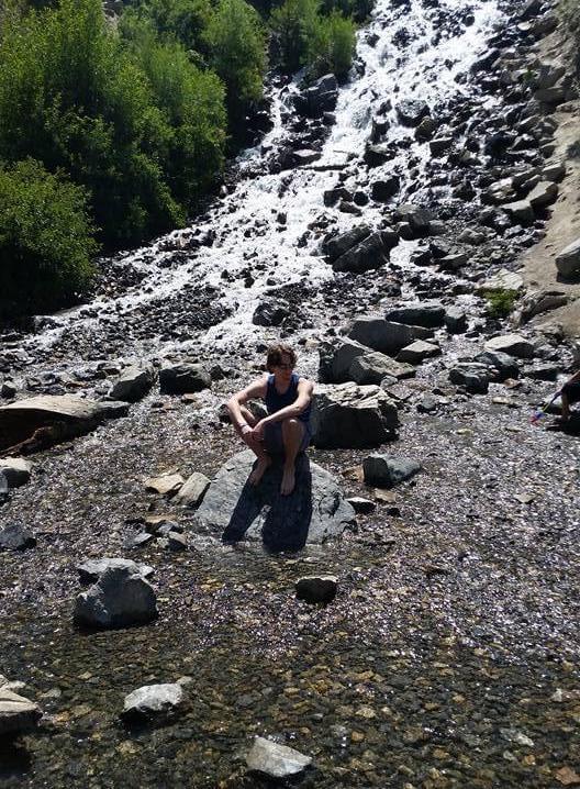 Chris sitting down while exploring a local waterfall.