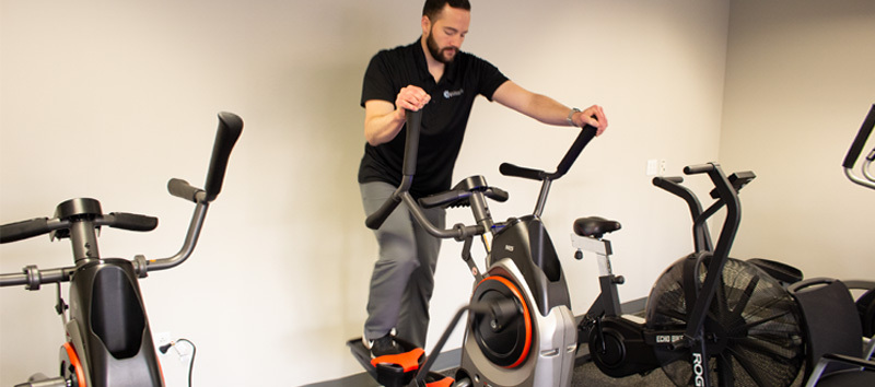 young man using a max trainer for concussion symptom relief